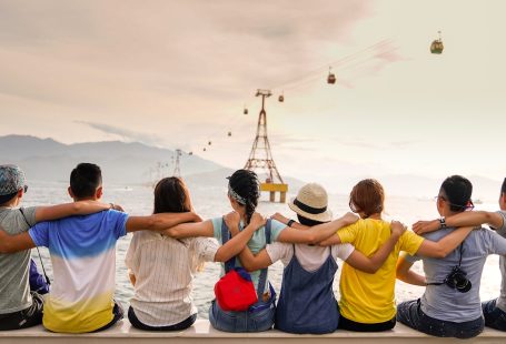 people holding shoulders sitting on wall