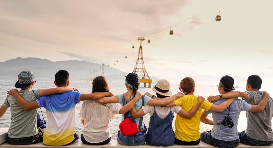 people holding shoulders sitting on wall